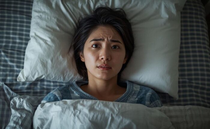 布団の中で横になっている女性